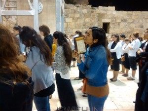 Photos Credit: Anav Silverman, Tazpit News Agency / Young Israeli woman prays for the safety of IDF soldiers on Saturday night at the Western Wall. 